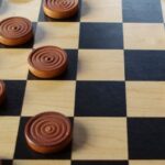 Image of a checkerboard pattern on a wooden table, ready for a game of Checkers unblocked